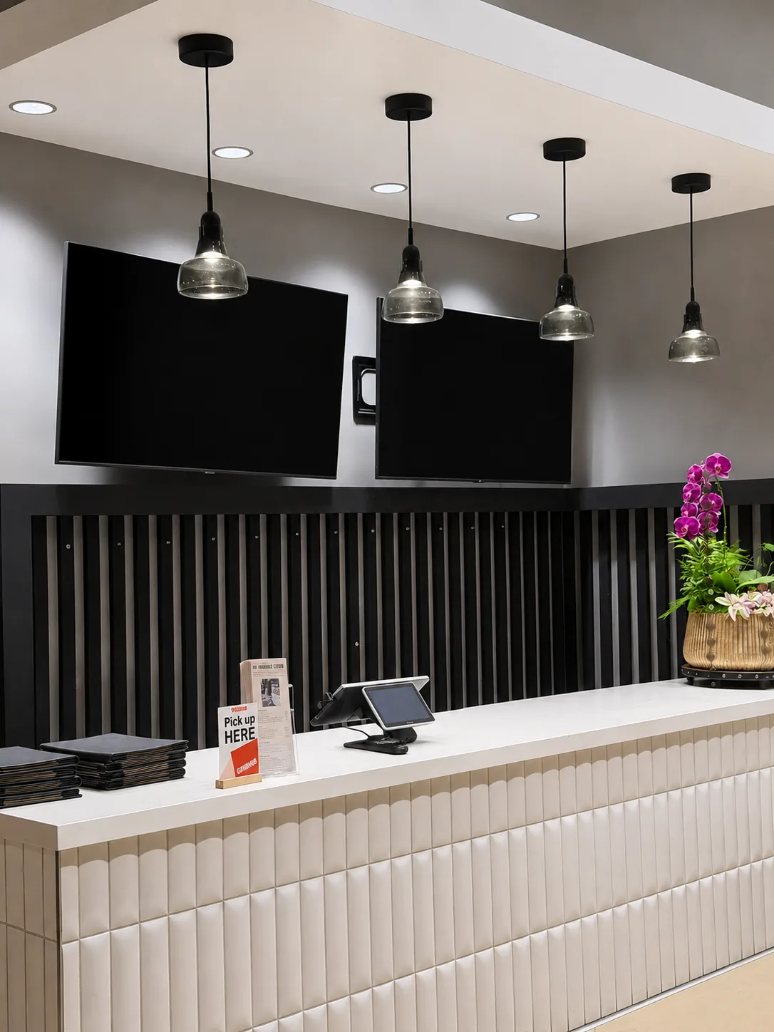 Wall-mounted digital menu boards behind a restaurant counter, ready for menu content